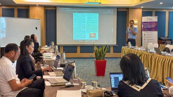 Un chercheur se tient &agrave; l&rsquo;avant d&rsquo;une salle de conf&eacute;rence et pr&eacute;sente un document projet&eacute; &agrave; l&rsquo;&eacute;cran, tandis que les participants suivent la pr&eacute;sentation depuis leurs places lors de la r&eacute;union annuelle de MALICA.